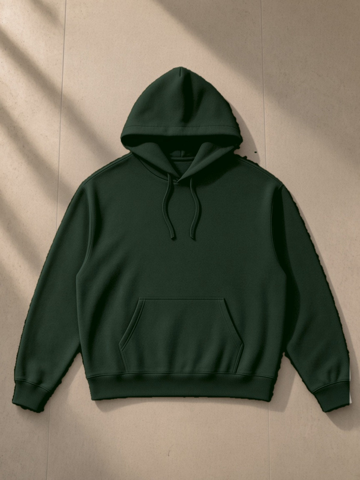 Essential Boxy Heavyweight Drop-Shoulder Hoodie in Blackish Green, laid flat on pale limestone, front view