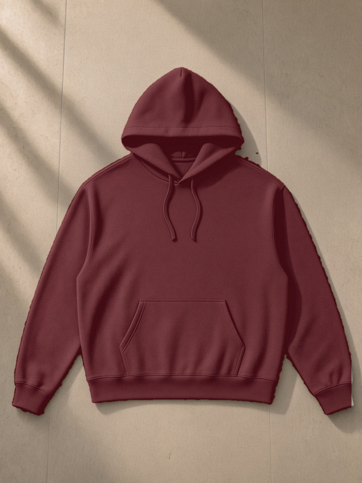 Essential Boxy Heavyweight Drop-Shoulder Hoodie in Dull Red, laid flat on pale limestone, front view