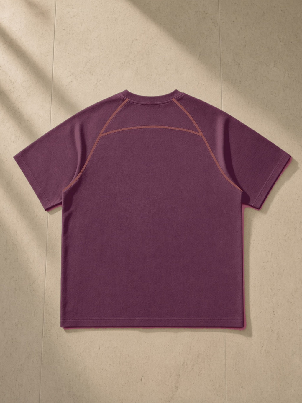 Contrast Stitch Raglan T-Shirt in Plum Purple, laid flat on pale limestone, back view