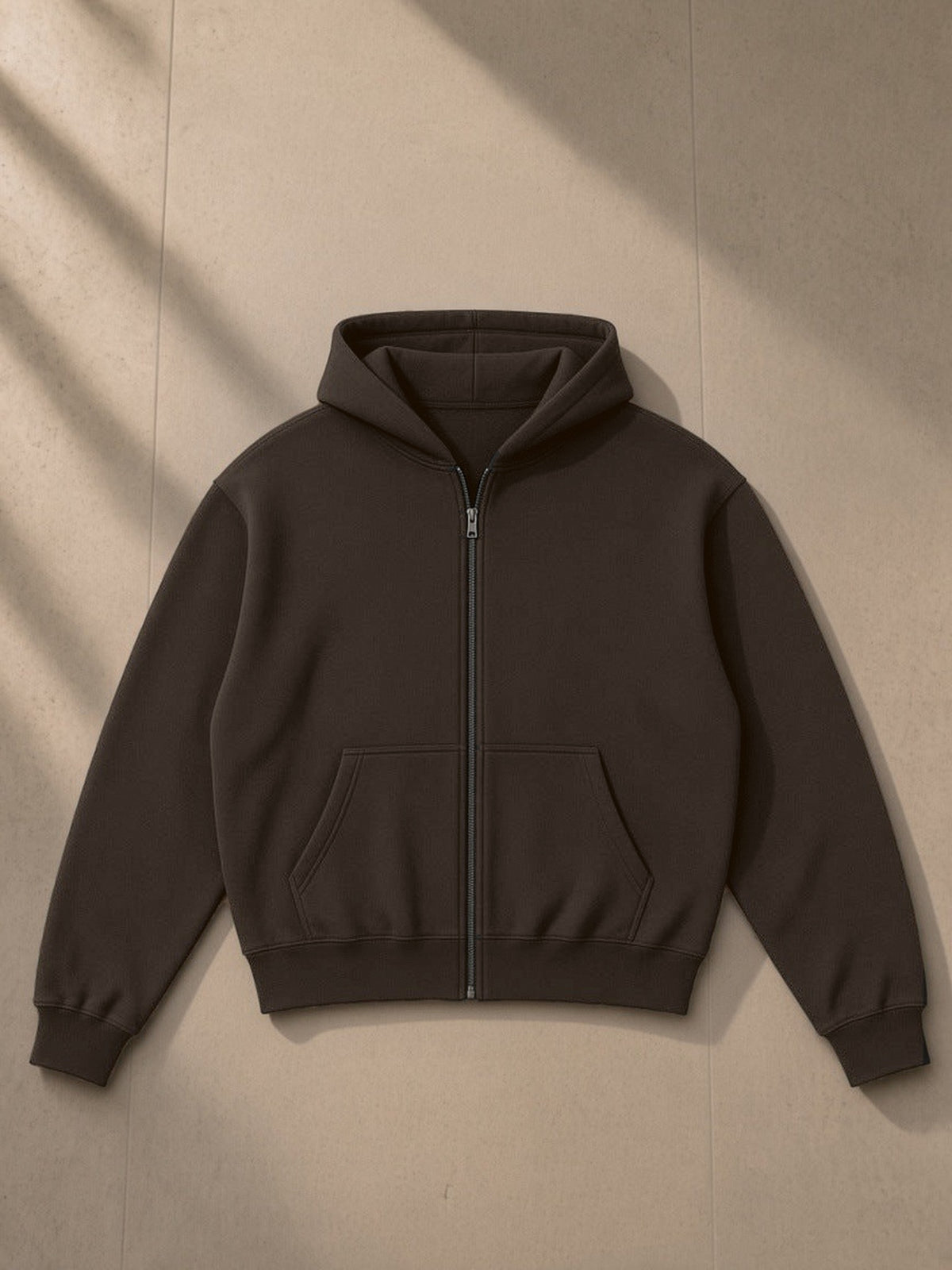 Unisex fleece zip-up boxy hoodie in Brown, laid flat on pale limestone, front view