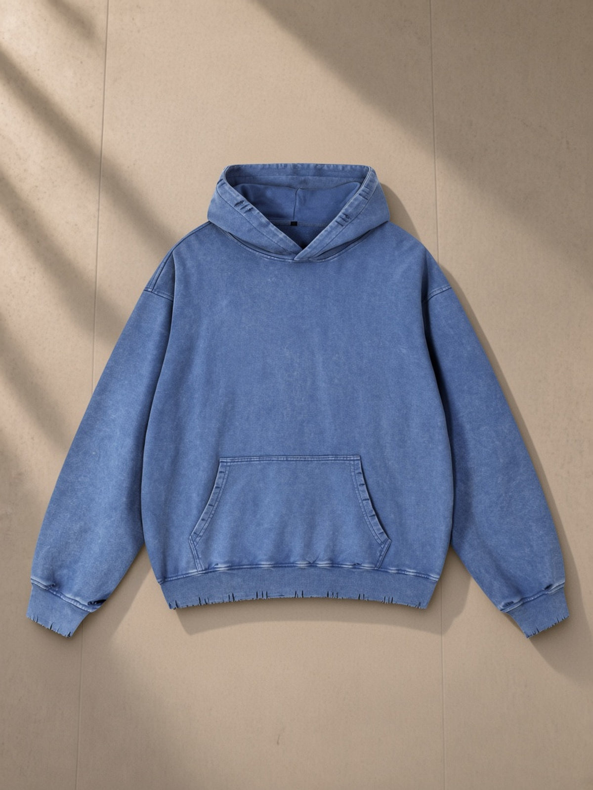 Snow Wash Hand-Frayed Heavyweight Hoodie in Royal Blue, laid flat on pale limestone, front view