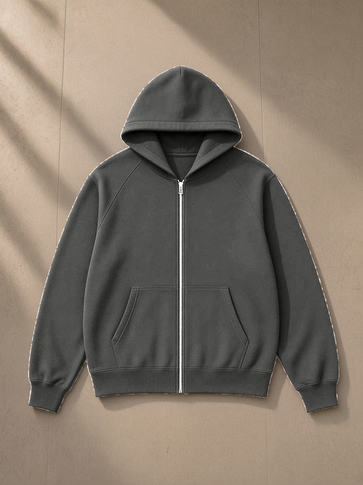 Essential zip-up fleece hoodie in Cement Gray, laid flat on pale limestone, front view
