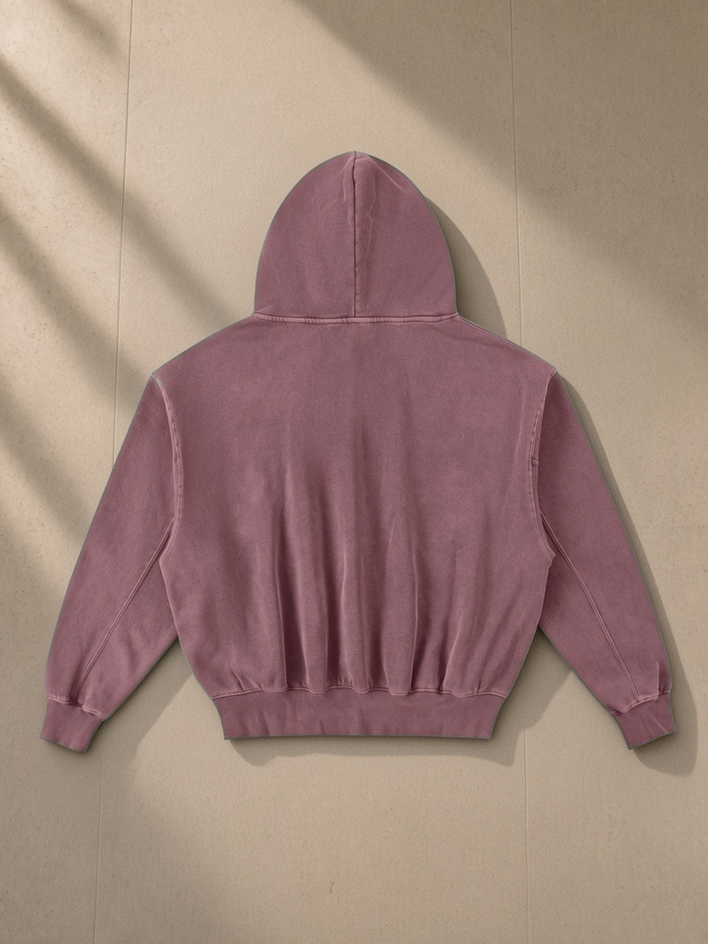 Frayed Enzyme Washed Fleece Hoodie in Red, laid flat on pale limestone, back view