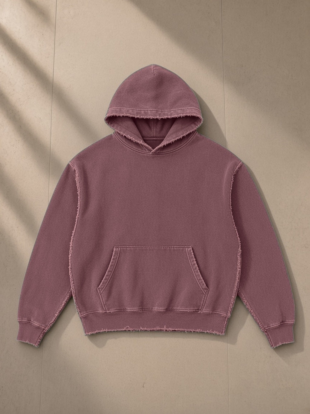 Frayed Enzyme Washed Fleece Hoodie in Red, laid flat on pale limestone, front view