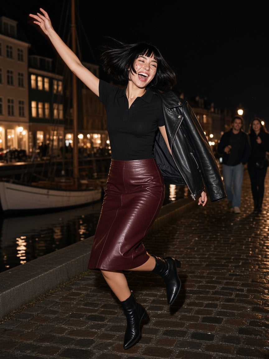 Woman in the Bodycon Short Sleeve Polo Shirt in Black with a burgundy leather midi skirt, jumping on a Copenhagen canal quay at 2am