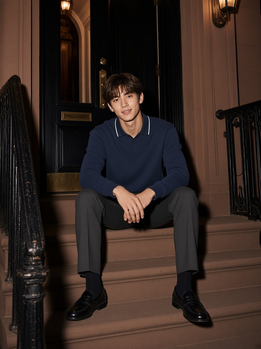 Man in the Boxy Detachable Collar Sweatshirt in Navy Blue seated on brownstone steps on Gramercy Park at night