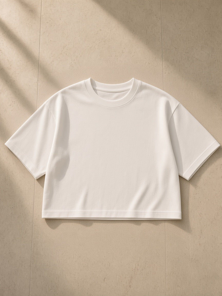 Boxy Drop Shoulder Crop T-Shirt in White, laid flat on pale limestone