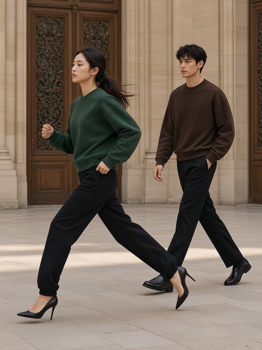 Two people in the Marcel Afters Boxy Fleece Crewneck Sweatshirt in Dark Green and Coffee walking fast through a Paris limestone courtyard