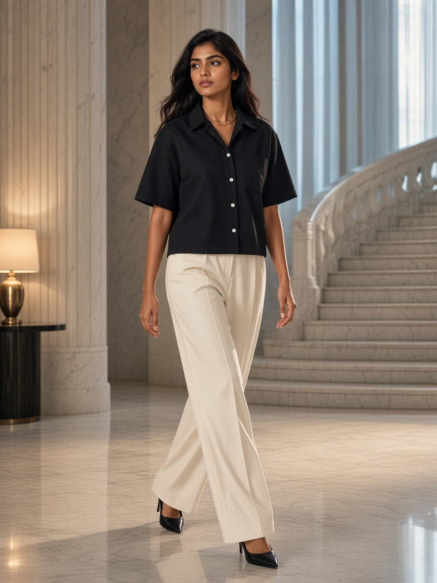 Woman in the Boxy Heavyweight Short Sleeve Shirt in Black in a marble hotel lobby in Mumbai at dawn