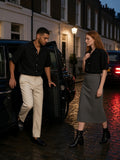 Two people in the Boxy Heavyweight Short Sleeve Shirt in Black, one stepping out of a cab and one waiting on the pavement, in a London mews at night