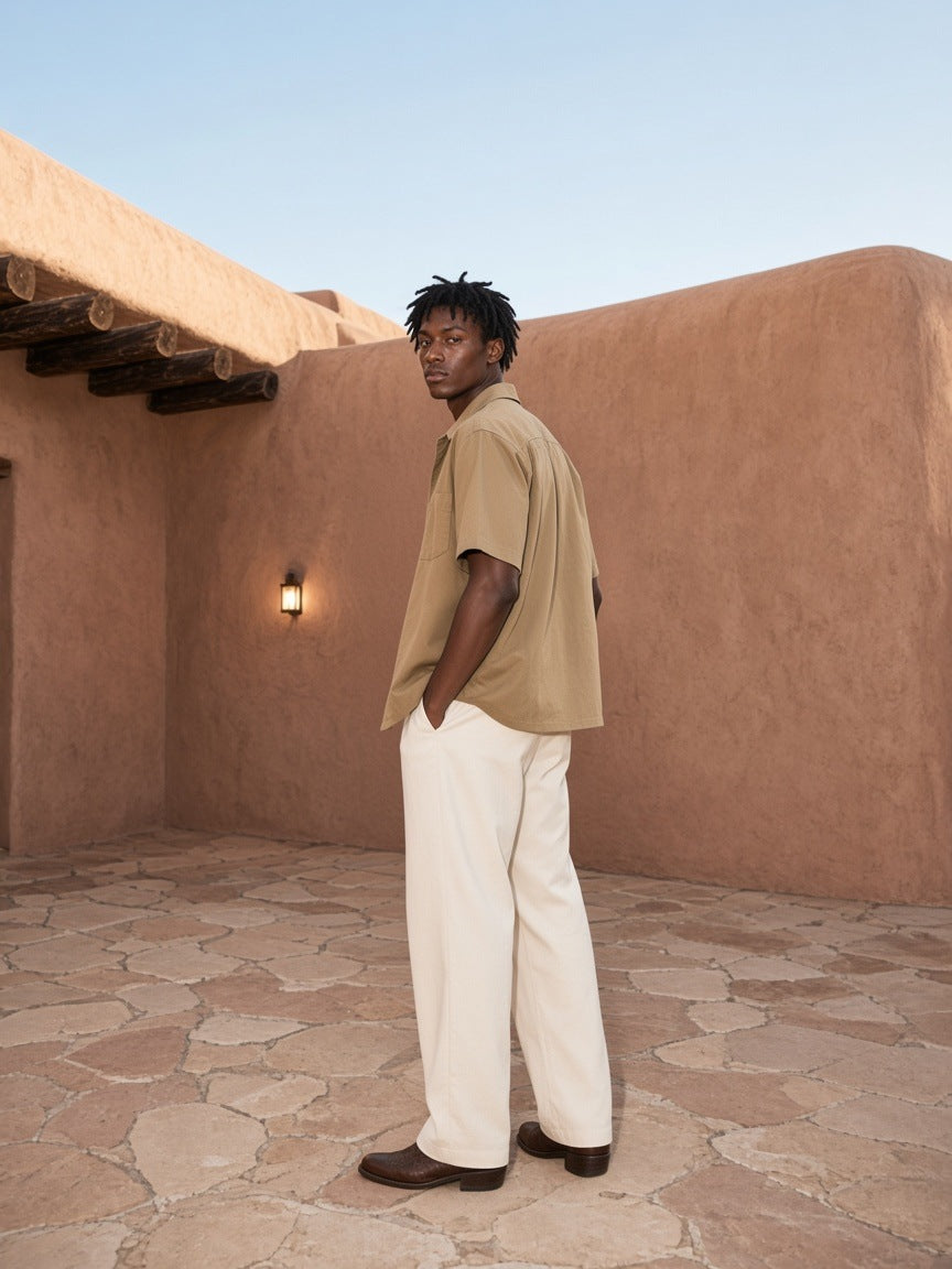 Man in the Boxy Heavyweight Short Sleeve Shirt in Khaki in an adobe hotel courtyard in Santa Fe by day