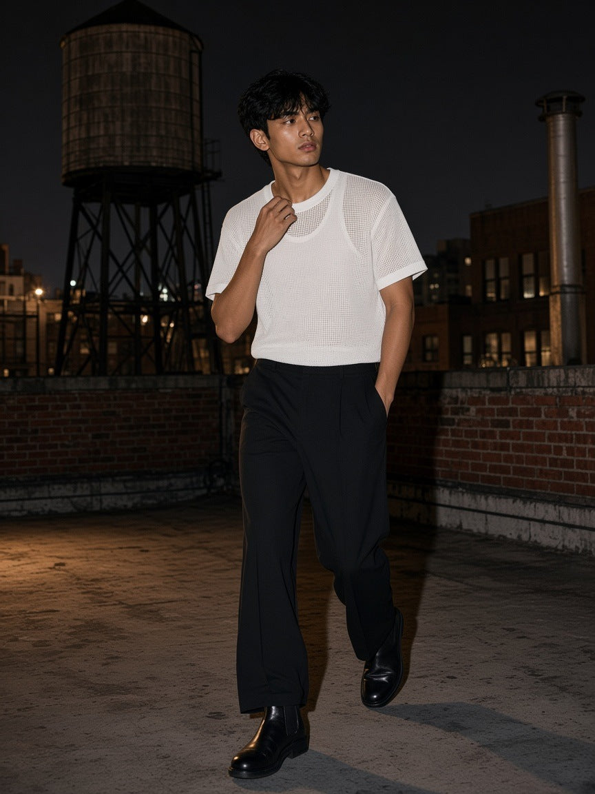 Man in the Boxy Mesh Crewneck T-Shirt in White leaning on a rooftop over the Hudson in New York at night