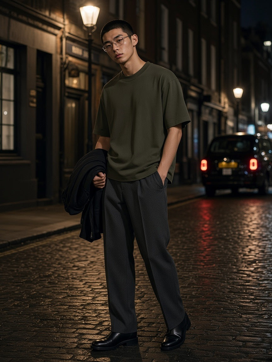 Man in the Boxy Oversized T-Shirt in Army Green in a cobbled mews off Soho Square in London at night