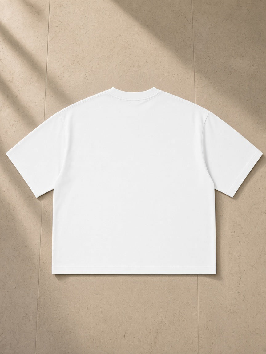Boxy Oversized T-Shirt in White, laid flat on pale limestone, back view