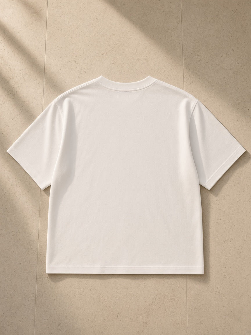 Women's Boxy Oversized T-Shirt in White, laid flat on pale limestone, back view