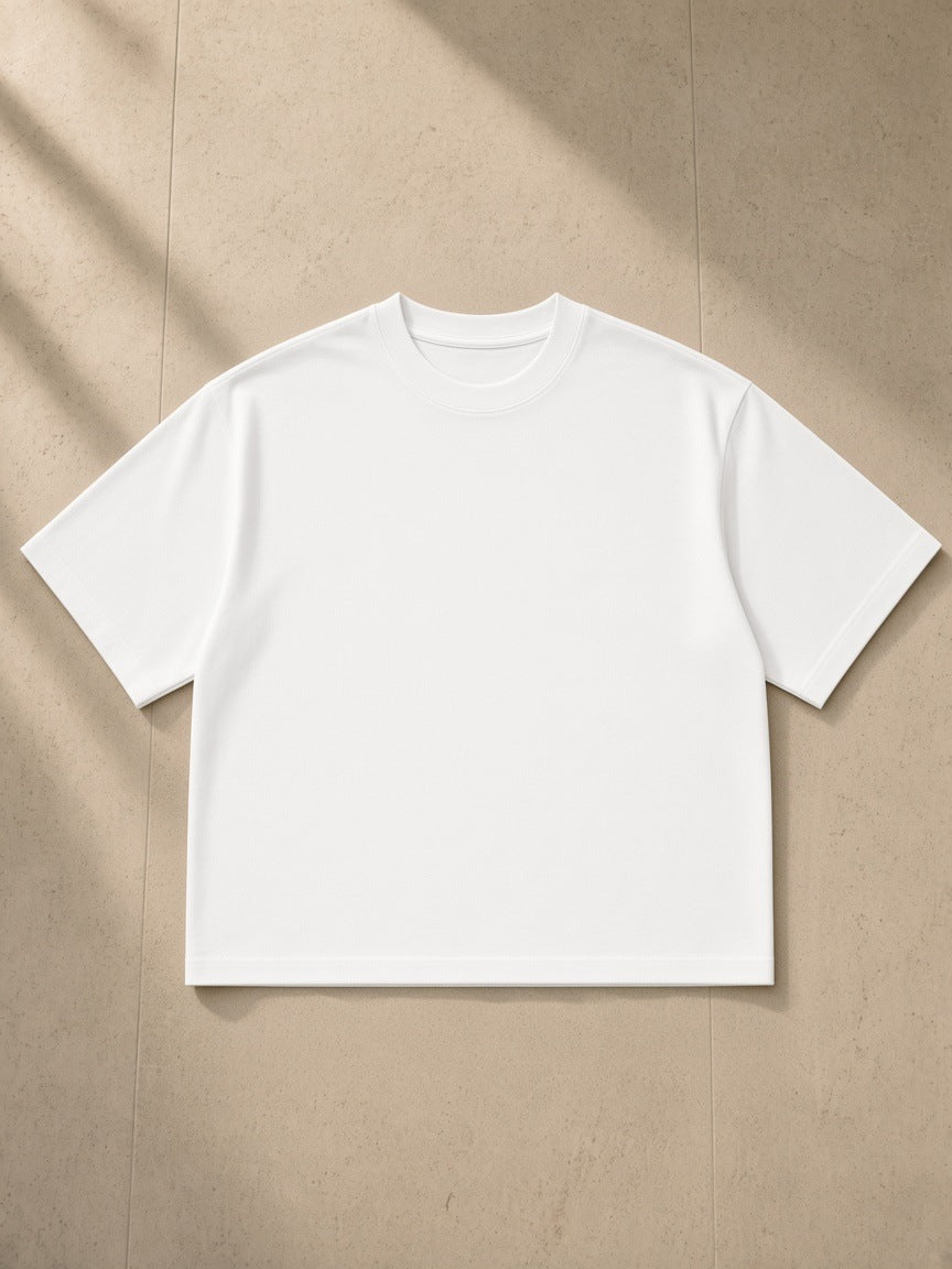 Boxy Oversized T-Shirt in White, laid flat on pale limestone