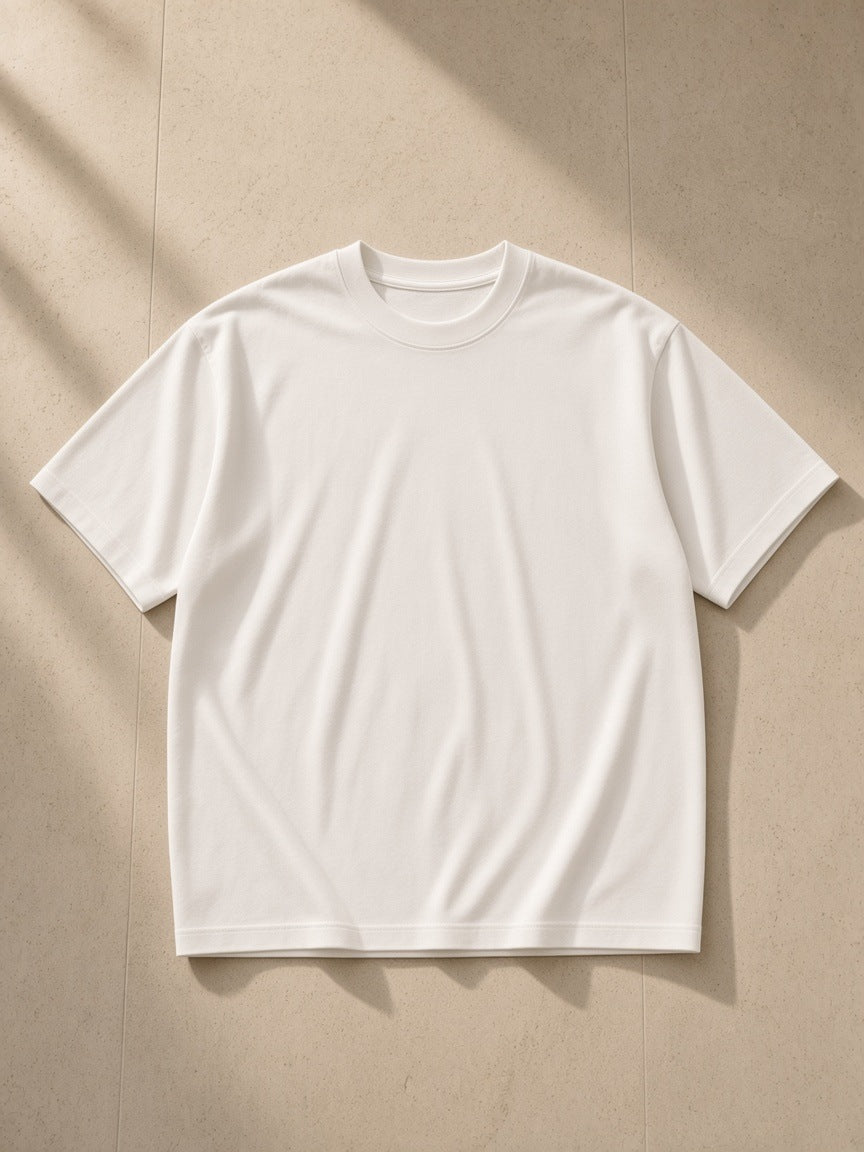 Men's Boxy Oversized T-Shirt in White, laid flat on pale limestone