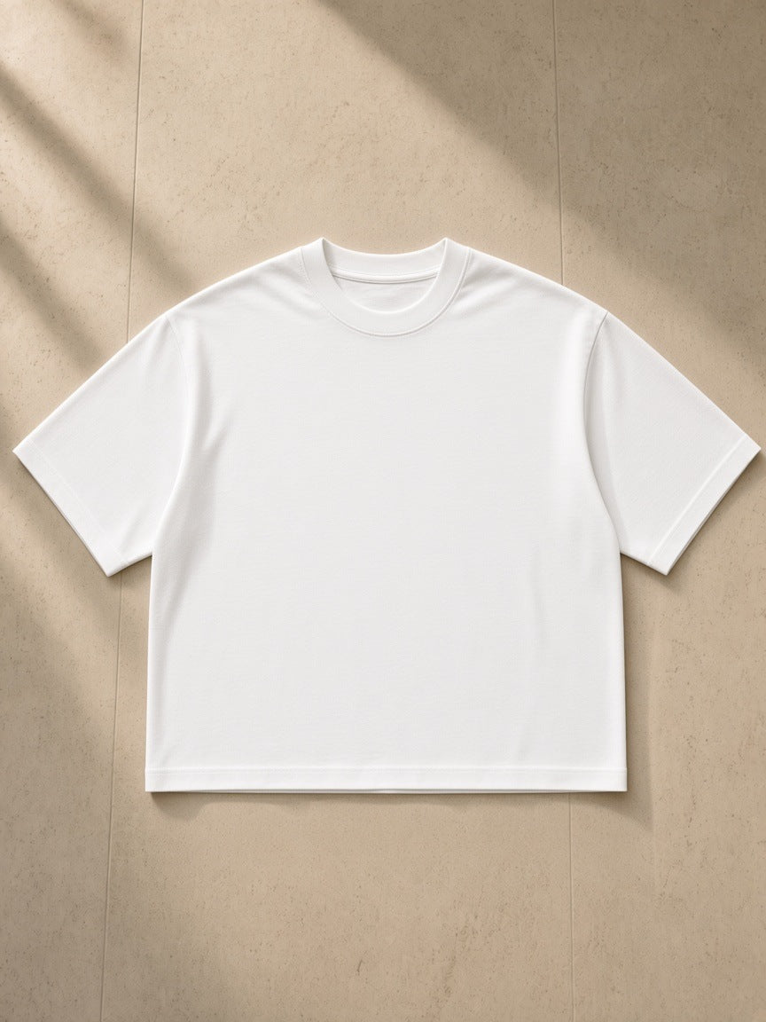 Boxy Oversized T-Shirt in White, laid flat on pale limestone