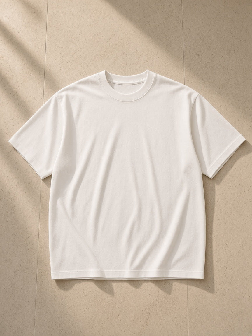 Men's Boxy Oversized T-Shirt in White, laid flat on pale limestone