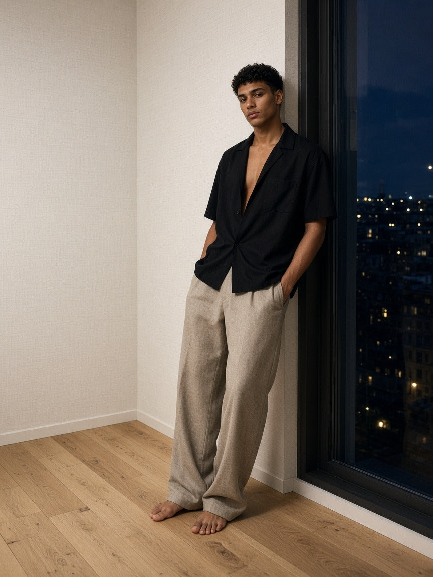 Man in the Marcel Afters Boxy Patch Pocket Short Sleeve Shirt in Black in a pale-oak hotel suite in Copenhagen at night