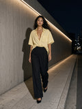 Woman in the Boxy Patch Pocket Short Sleeve Shirt in Apricot walking a concrete street in Aoyama, Tokyo at night
