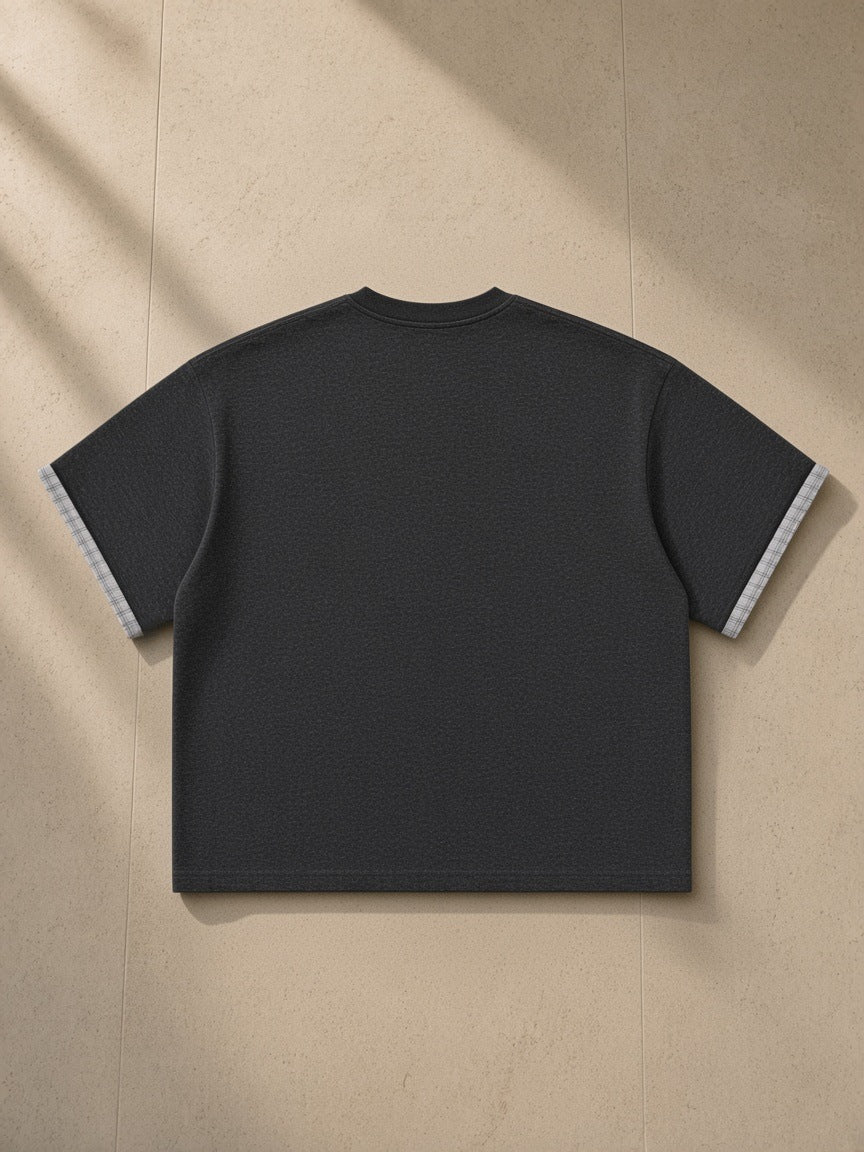 Boxy Plaid-Lined Double-Face T-Shirt in Black, laid flat on pale limestone, back view