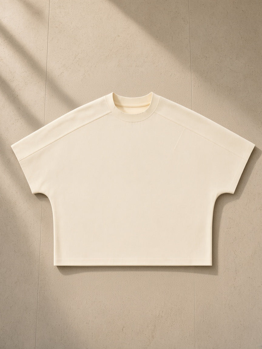 Boxy Tonal Paneling T-Shirt in Apricot, laid flat on pale limestone