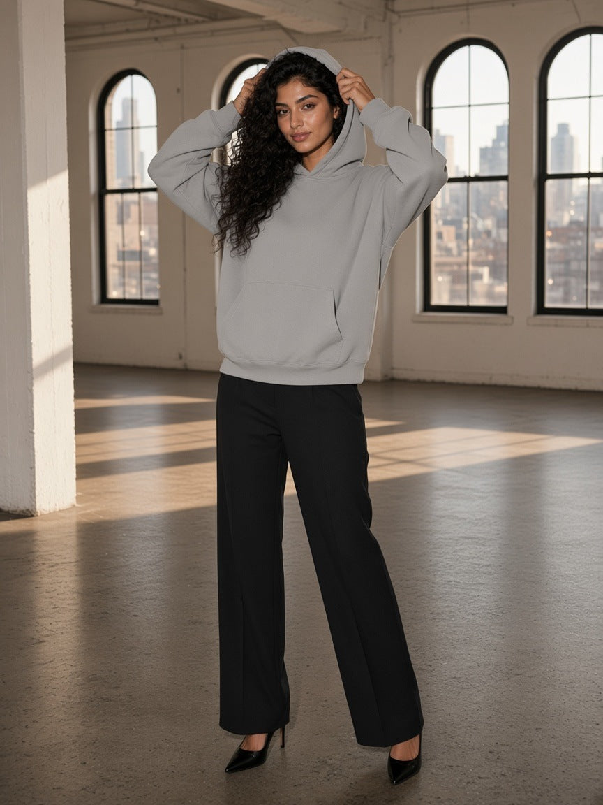 Woman in the Boxy Vintage Washed Hoodie in Light Gray walking through a cast-iron loft in Tribeca, New York by day