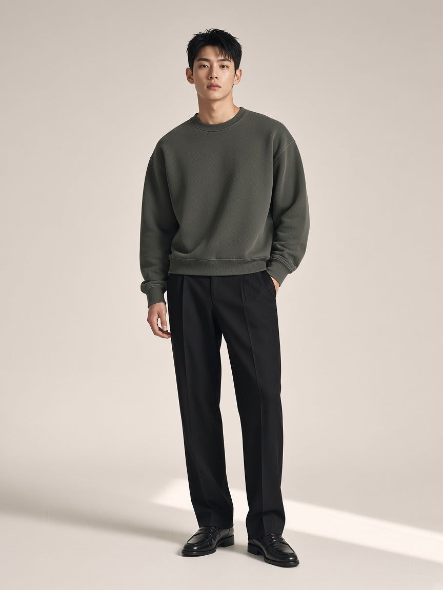 Man in the Boxy Vintage Washed Sweatshirt in Dark Gray on a bone paper studio set