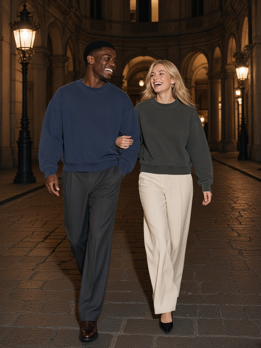 Two people in the Boxy Vintage Washed Sweatshirt in Navy Blue and Dark Gray in a Milan palazzo courtyard at night