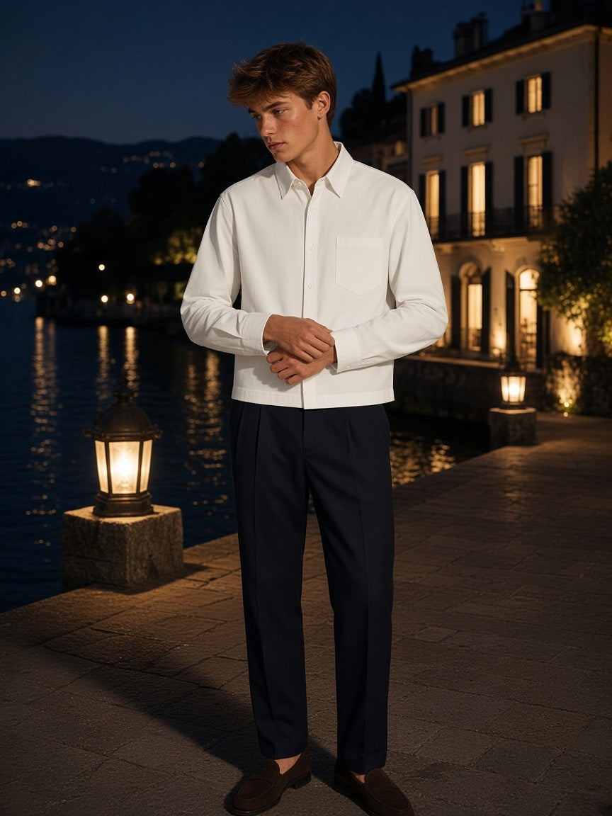 Man in the Button-Front Long Sleeve Shirt in White, fastening a cuff on a villa dock on Lake Como at night