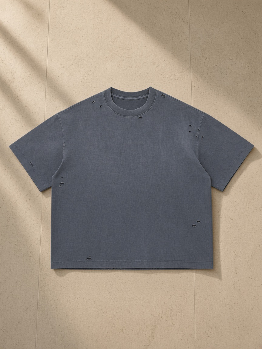 Vintage Washed Distressed Boxy Oversized T-Shirt in Blue, laid flat on pale limestone