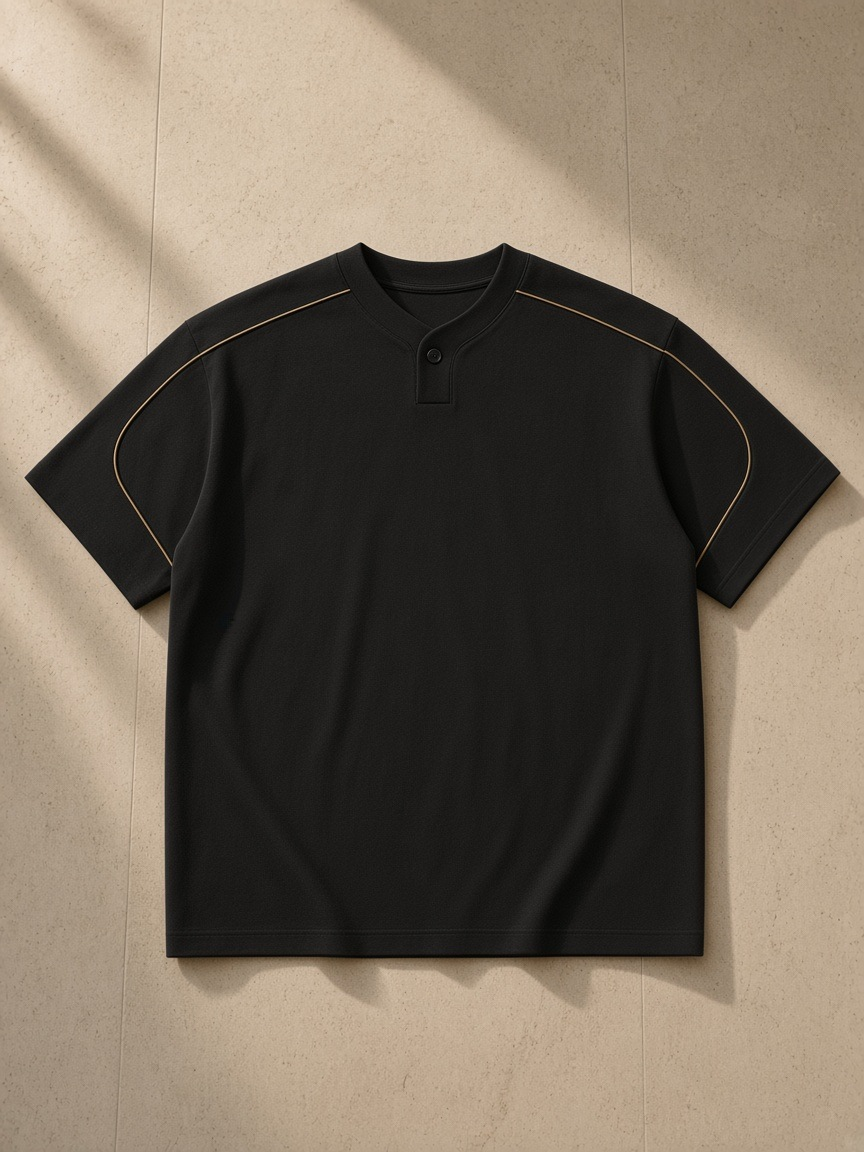 Oversized piping henley t-shirt in Black, laid flat on pale limestone