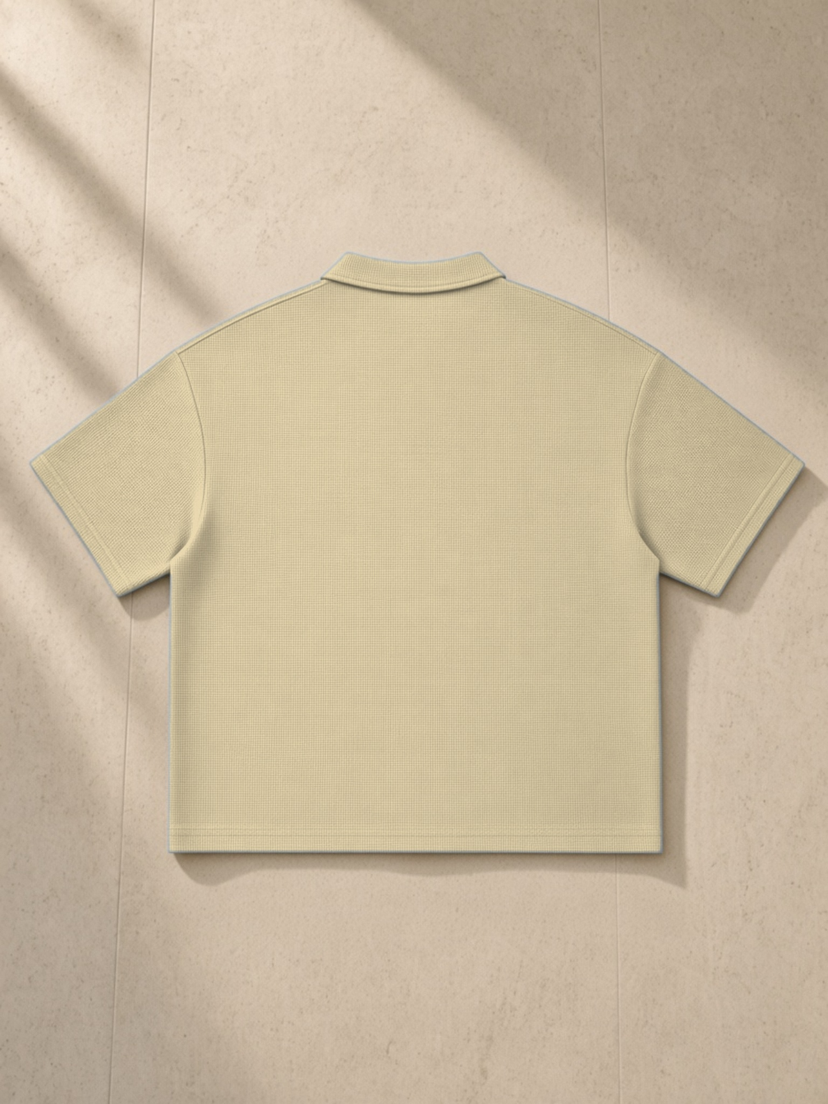 Vintage Wash Waffle Boxy Polo Shirt in Khaki, laid flat on pale limestone, back.