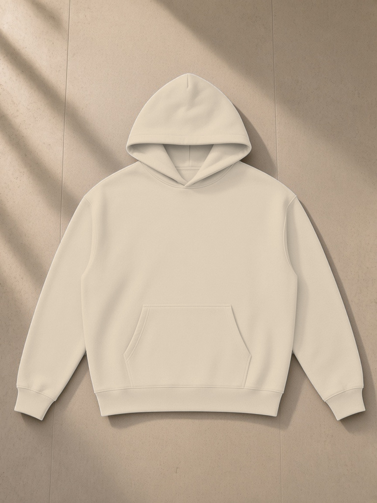 Essential Heavyweight Hoodie in Apricot, laid flat on pale limestone, front.