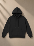 Streetwear Fleece Hoodie in Black, laid flat on pale limestone