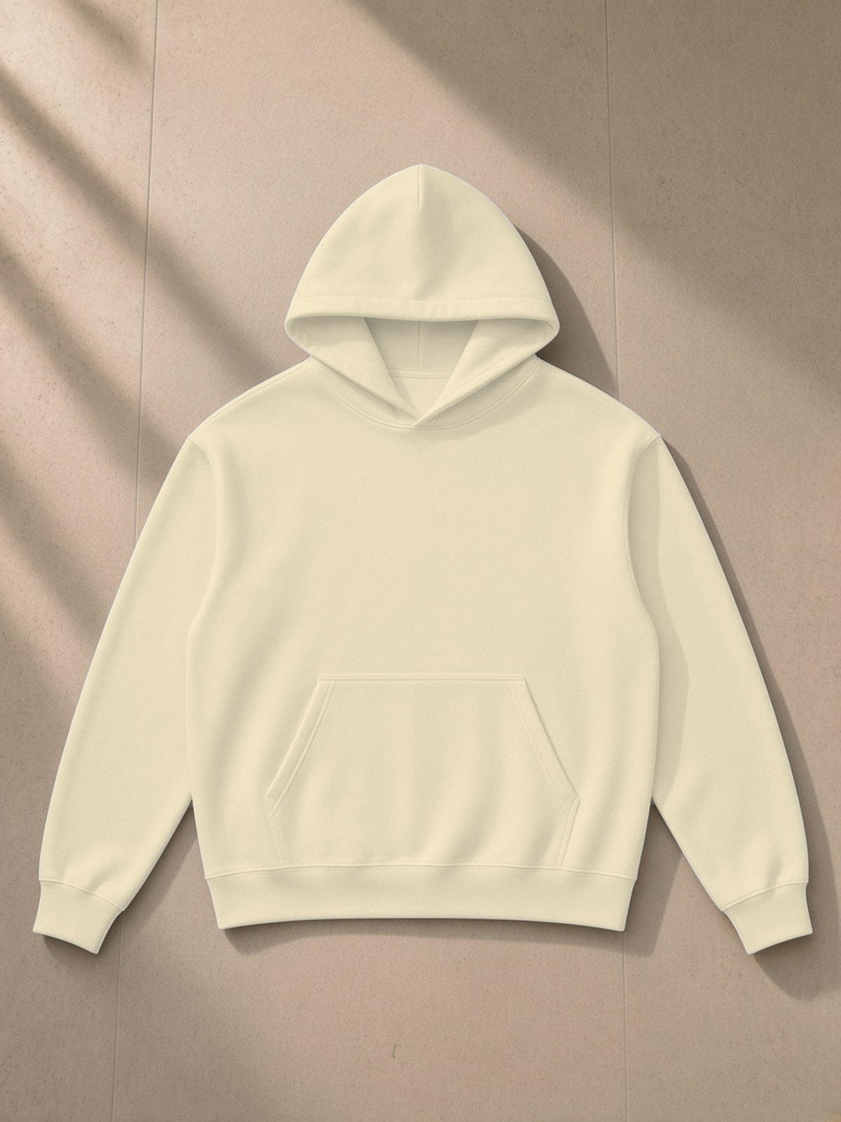 Essential Heavyweight Drop-Shoulder Hoodie in Mild Apricot, laid flat on pale limestone, front.