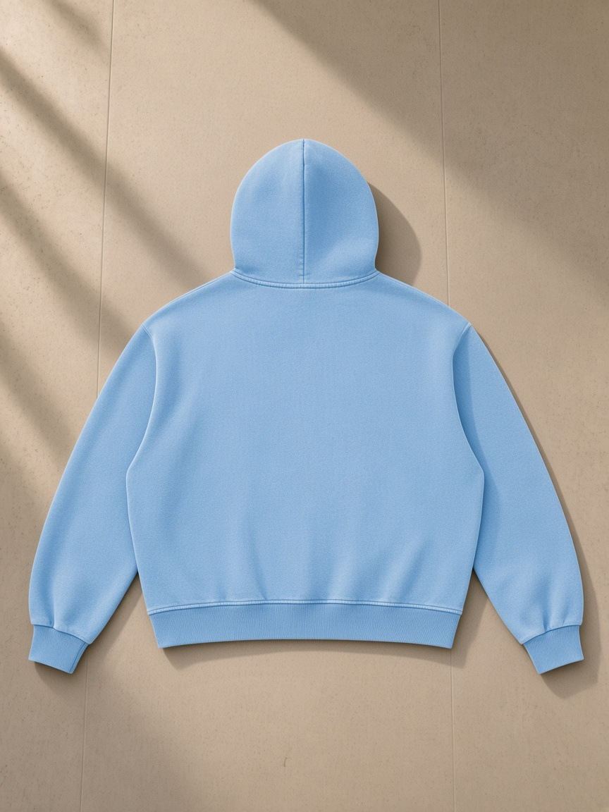 Vintage Wash Boxy Fleece Hoodie in Light Blue, laid flat on pale limestone, back view