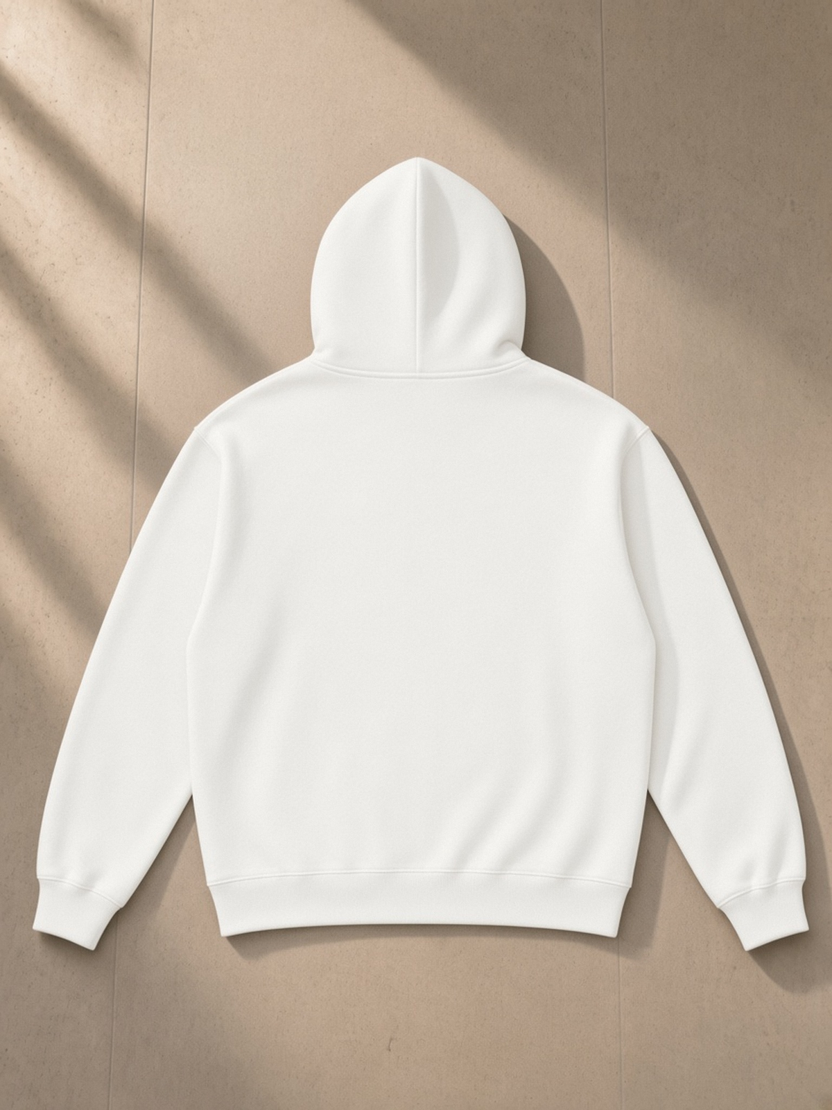 Relaxed Fit Hoodie in White, laid flat on pale limestone, back.