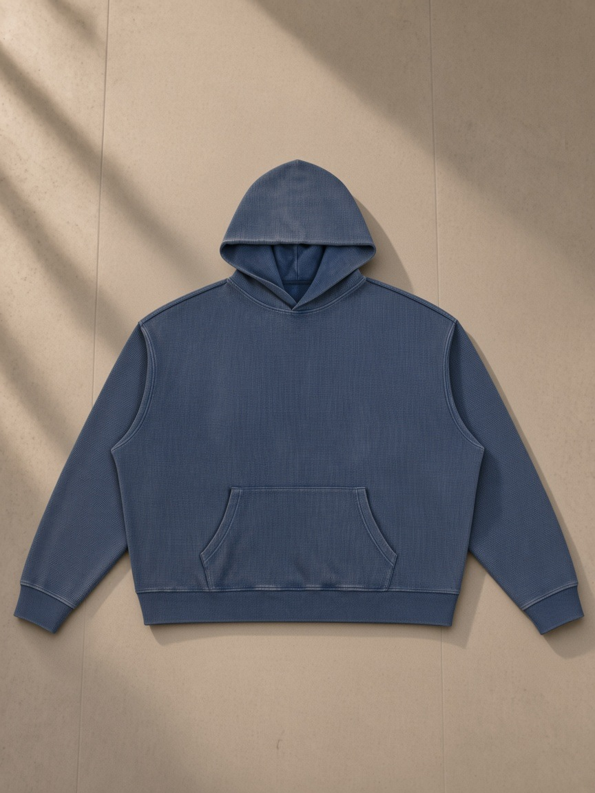 Vintage Wash Waffle Boxy Hoodie in Navy Blue, laid flat on pale limestone, front.