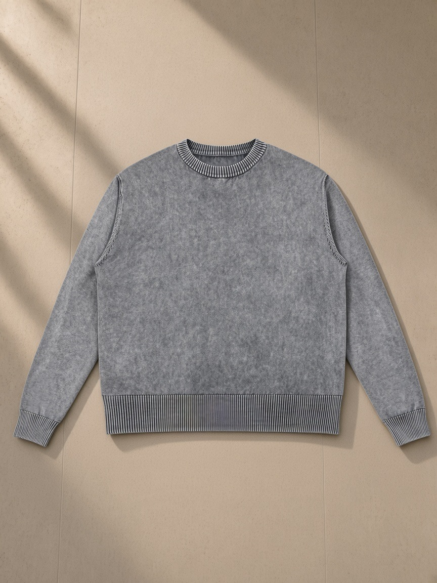 Mineral Wash Crewneck Sweater in Gray, laid flat on pale limestone