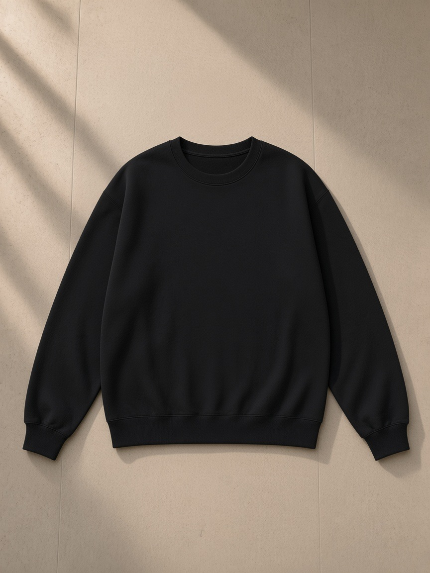 Unisex heavyweight drop shoulder sweatshirt in Black Beauty, laid flat on pale limestone