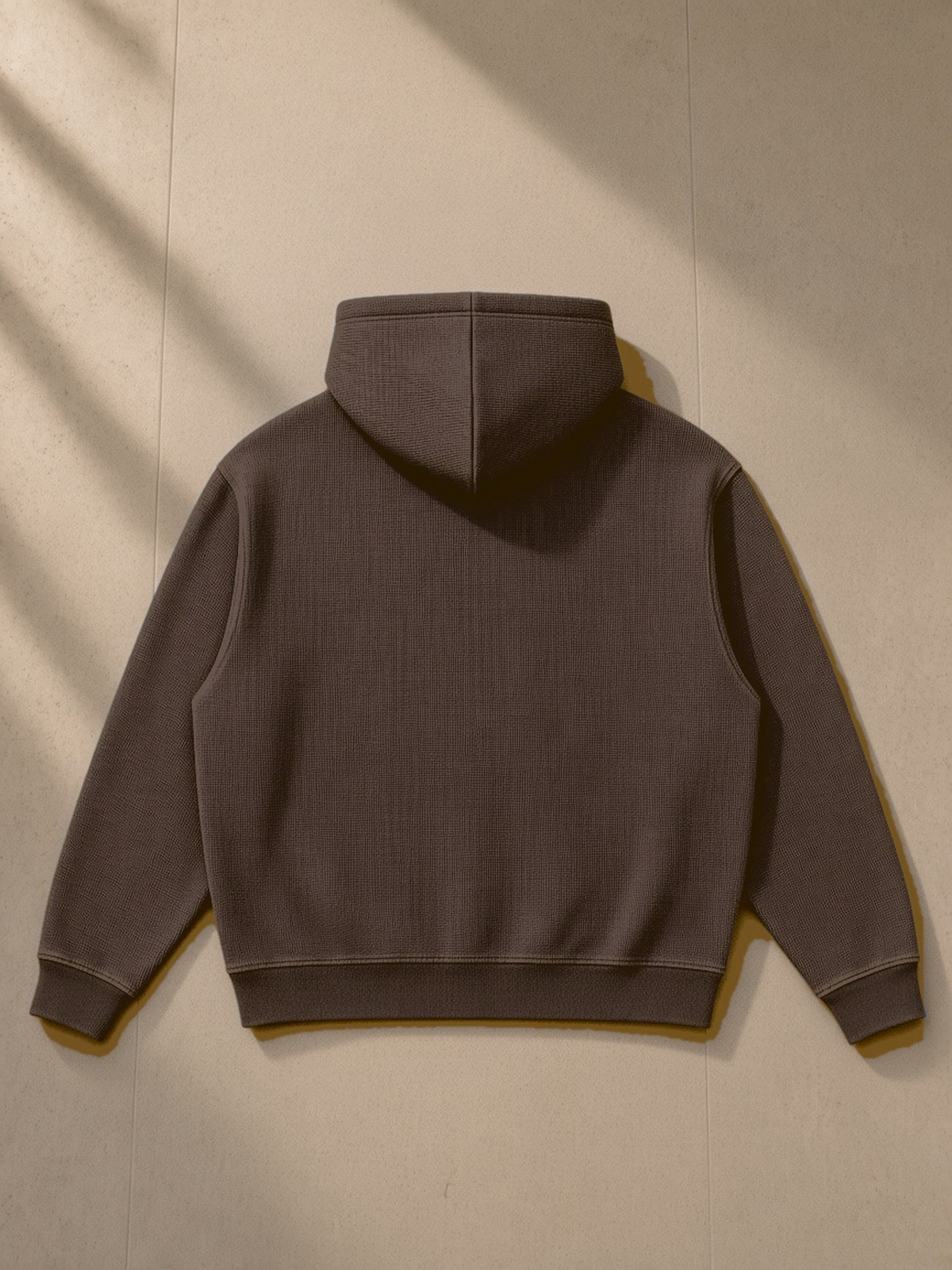 Vintage Wash Waffle Boxy Hoodie in Brown, laid flat on pale limestone, back view