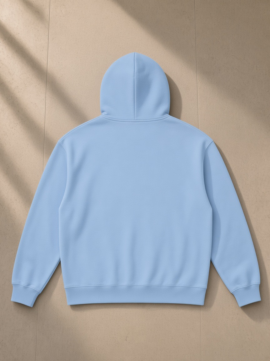 Heavyweight pullover hoodie in Sky Blue, laid flat on pale limestone, back view