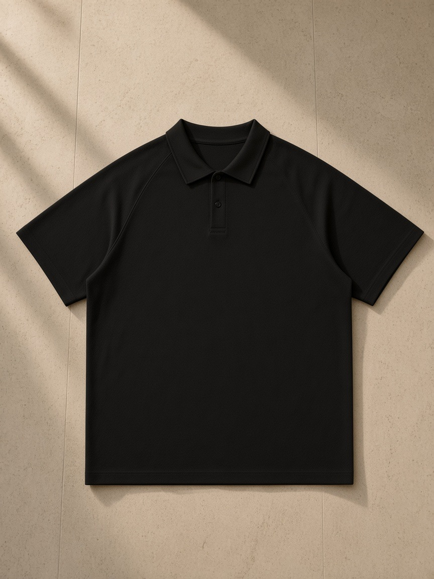 Classic Knit Polo in Black, laid flat on pale limestone