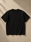 Unisex tonal paneled performance t-shirt in Black, laid flat on pale limestone