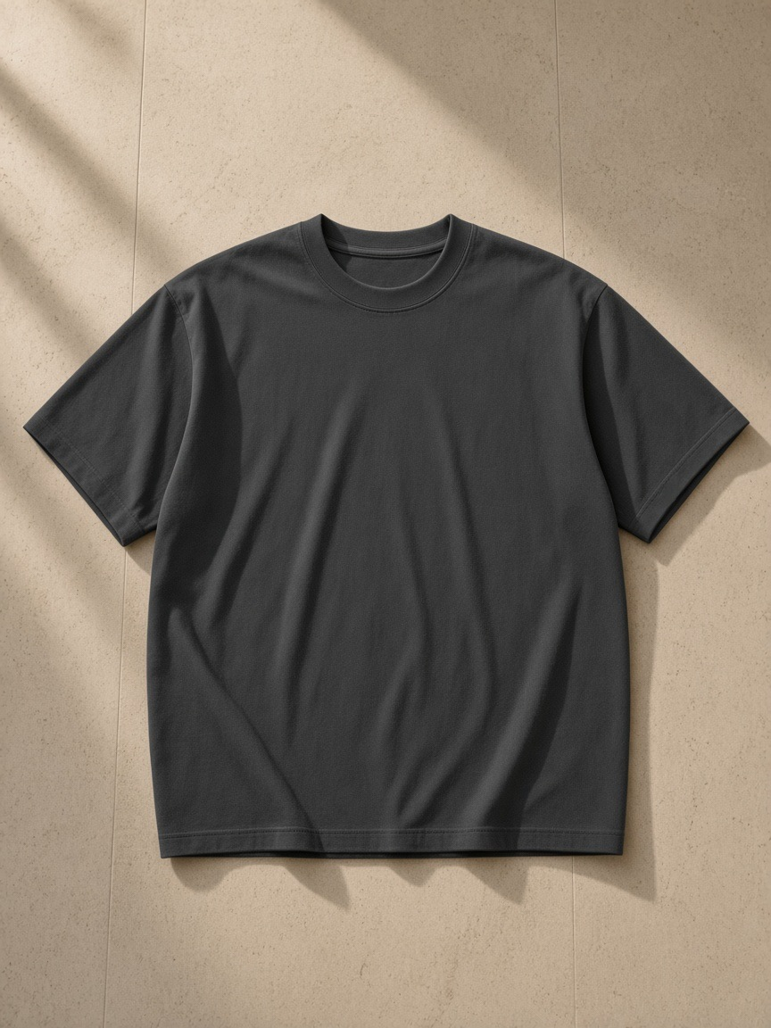 Men's Heavyweight Earth Tone T-Shirt in Carbon Gray, laid flat on pale limestone