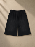 Unisex sunfade raw edge shorts in Black, laid flat on pale limestone