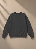 Unisex heavyweight drop shoulder sweatshirt in Charcoal, laid flat on pale limestone