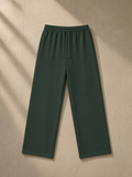 Straight Leg Sweatpants in Blackish Green, laid flat on pale limestone